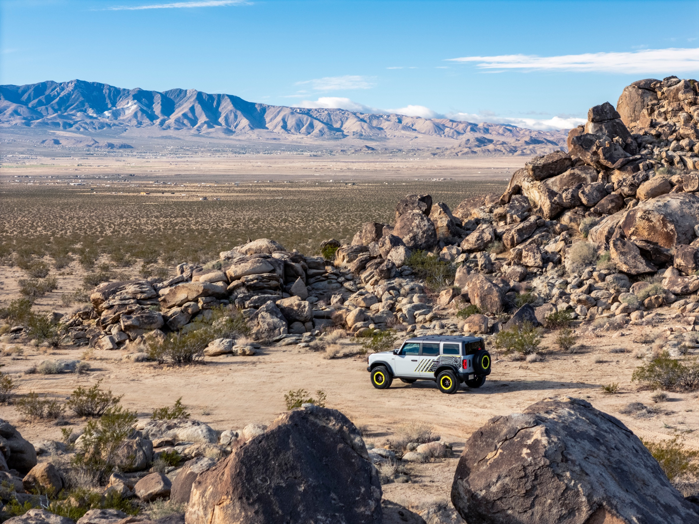 2027 Ford Bronco RTR crossing a wide desert landscape