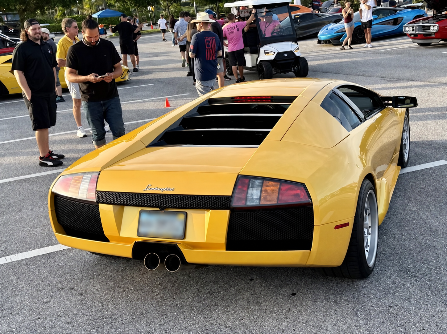 Rear three-quarter view of a yellow Lamborghini Murciélago with its license plate blurred